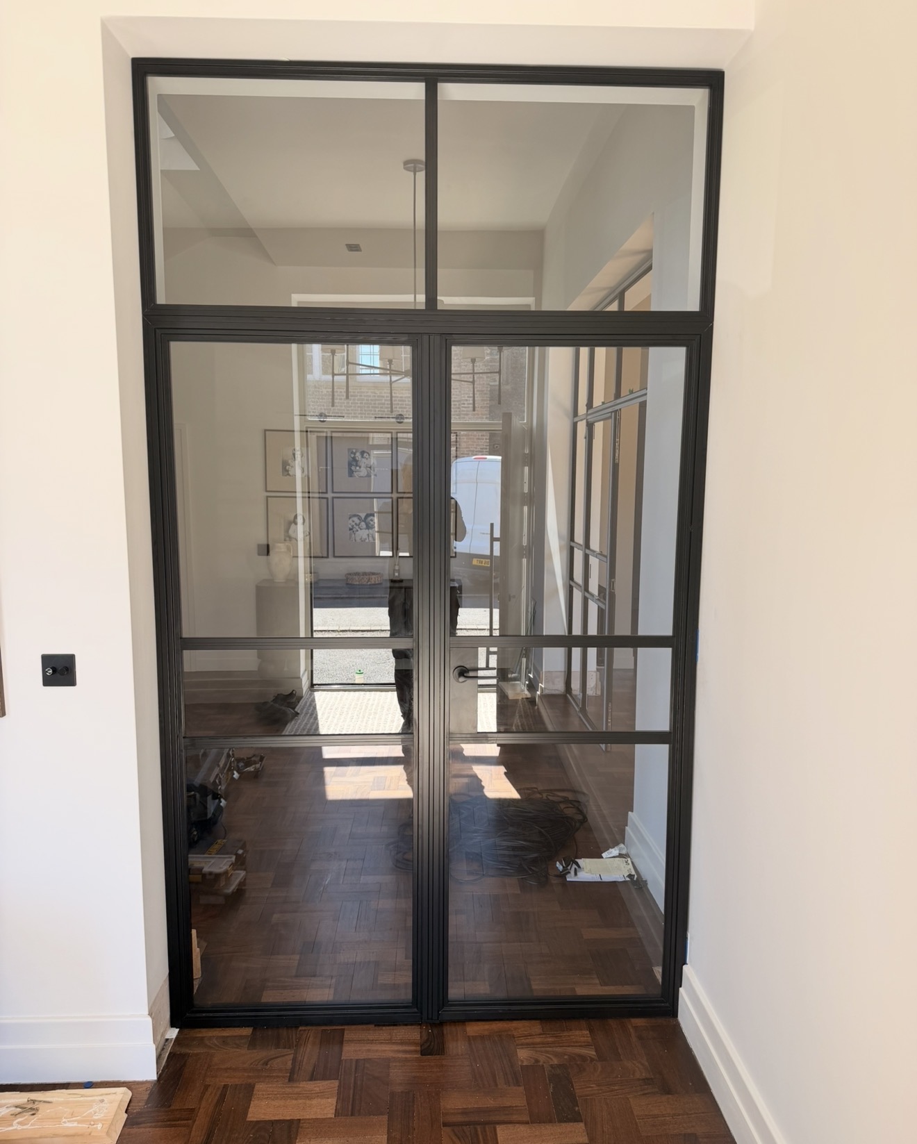 Matt black aluminium double doors with overhead fixed light in a hallway